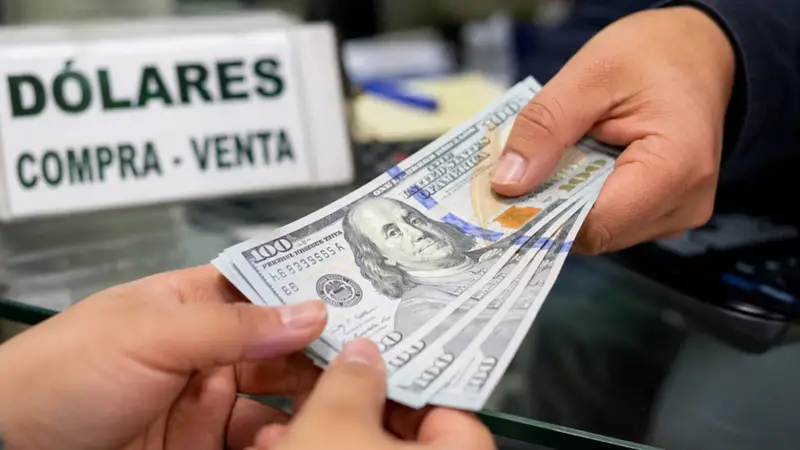 Personas realizan una transacción con dólares estadounidenses, una divisa cuya cotización en el mercado paralelo es seguida de cerca por ciudadanos y sectores económicos en Bolivia. (Foto: IA) Personas realizan una transacción con dólares estadounidenses, una divisa cuya cotización en el mercado paralelo es seguida de cerca por ciudadanos y sectores económicos en Bolivia. (Foto: IA)
